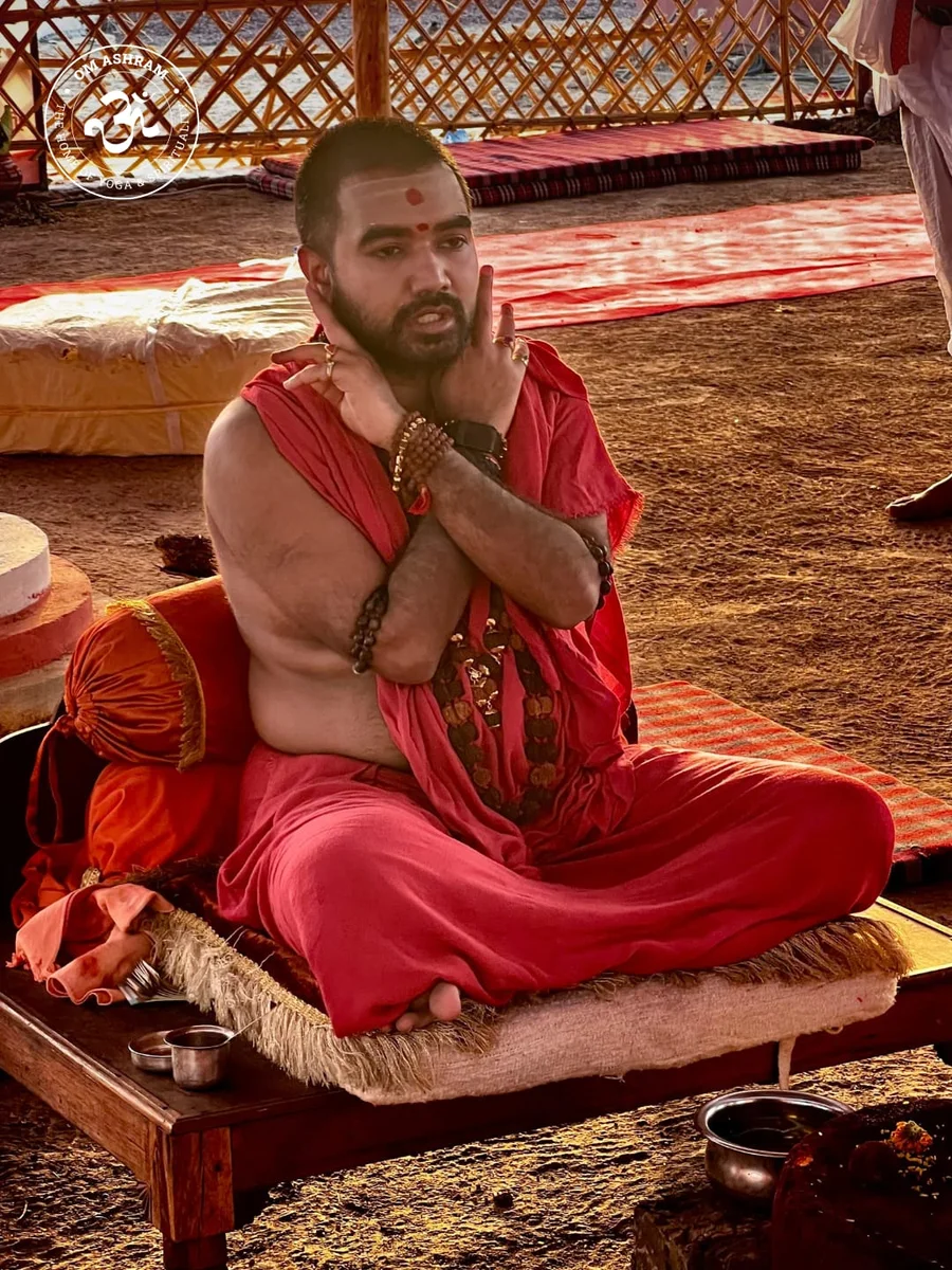Param Pujya Mahamandaleshwar Shree Swami Avatar Puri Ji Maharaj with arms crossed during the fire ritual.